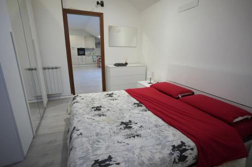- une chambre avec un grand lit et une couverture rouge dans l'établissement ClaRo Appartamento intero, à Limbiate