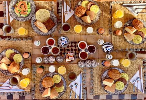 een tafel vol borden met eten en kommen met brood bij Riad Selouane in Marrakesh
