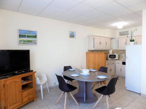 une cuisine avec une table avec des chaises et un réfrigérateur dans l'établissement Saint Georges de Didonne - APPARTEMENT rez-de-chaussée - mode TOUT à PIED, à Saint-Georges-de-Didonne