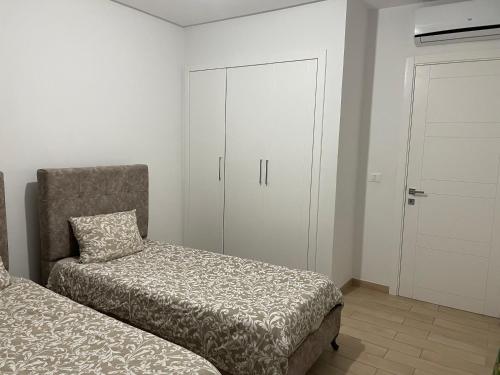 a bedroom with a bed and a chair and a closet at Appartement Les Pergolas in Ariana
