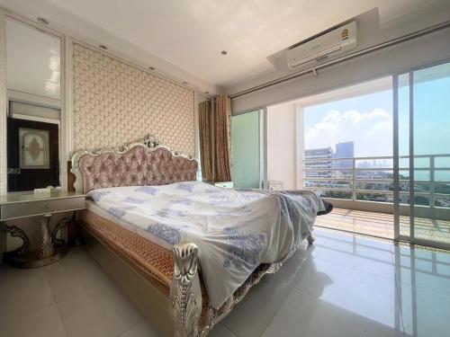 um quarto com uma cama e uma grande janela em Beautiful sea view beach front condo em Pattaya Sul