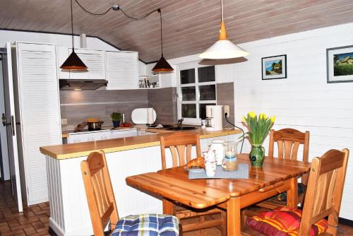 a kitchen with a wooden table and a table and chairs at Villa Lullyhill in Bargum