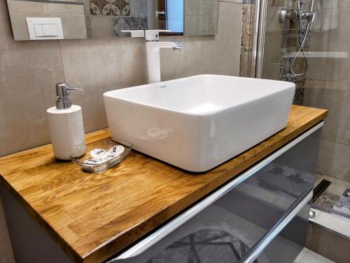 a white sink on a wooden counter in a bathroom at Casa Feli in Braşov