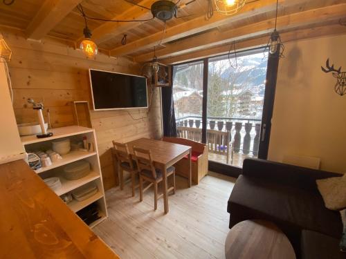a living room with a dining room table and a window at Appartement 290 Moulin B - 1200 Châtel - Linga in Châtel