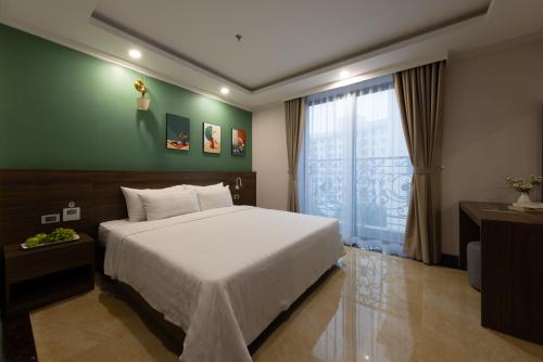 a bedroom with a large bed and a window at Nature Hotel in Hanoi