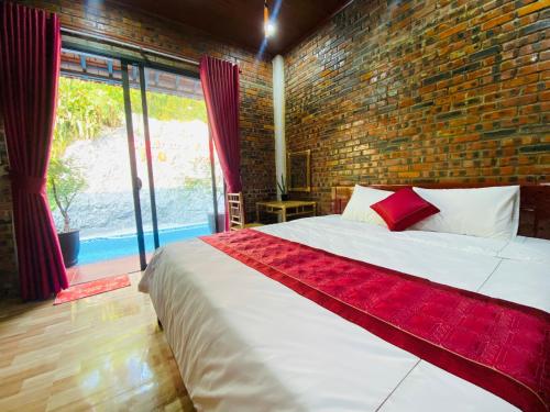 a bedroom with a large bed with a brick wall at Sunshine villa thuy bieu in Hue