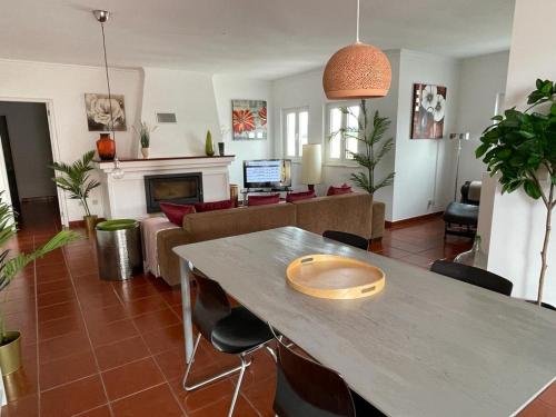 a living room with a table and a couch at Penthouse Alentejana in Vila Nova de Milfontes