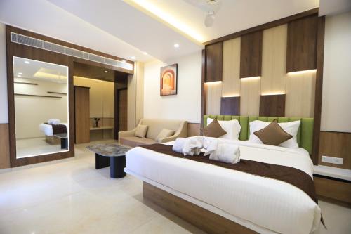 a bedroom with a large bed and a living room at Kings Bury Inn in Kumbakonam
