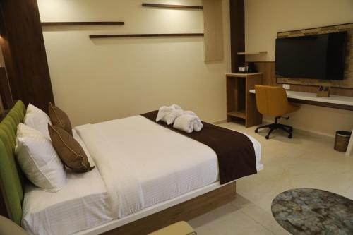 a bedroom with a bed with a stuffed animal on it at Kings Bury Inn in Kumbakonam