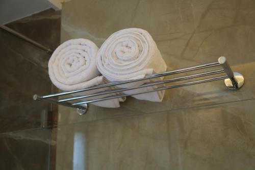 two towels on a glass shelf in a bathroom at Kings Bury Inn in Kumbakonam