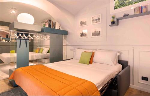 sypialnia z łóżkiem z pomarańczowym kocem w obiekcie Lata Rana Colosseum Luxury Loft w Rzymie