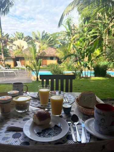een tafel met een bord eten en drinken bij Pousada Bangalô de Barro in Paraty