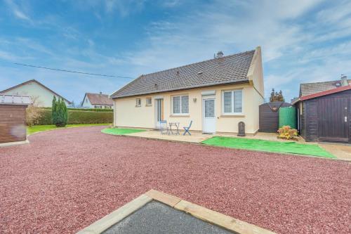 Una casa con un camino de entrada de grava en frente de ella en La Maresquerie, en Grandcamp-Maisy