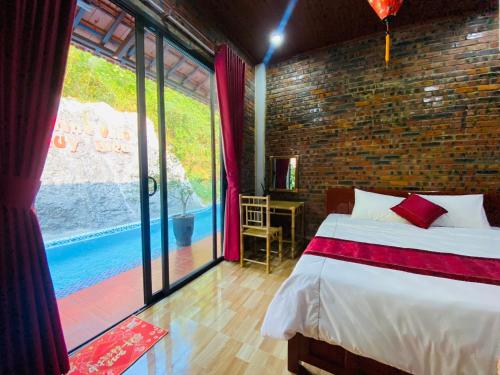 a bedroom with a bed and a large window at Sunshine villa thuy bieu in Hue