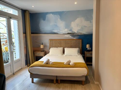 a bedroom with a bed with two towels on it at Mosaikhotel in Saint-Jean-de-Luz