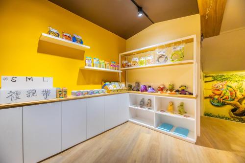 a room with yellow walls and shelves with toys at King Hot Spring Hotel in Jiaoxi