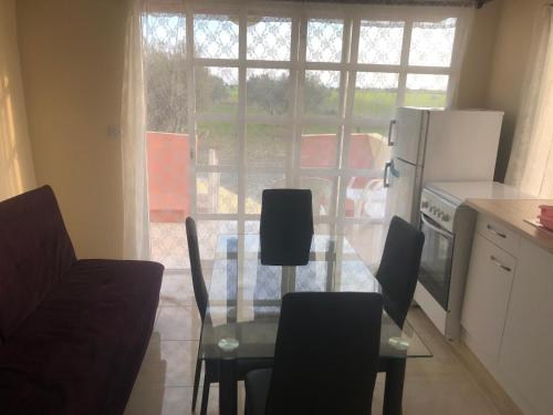 a kitchen with a glass table with chairs and a refrigerator at MERSINERA Paradise Garden NOAH HOUSE in Kivisil