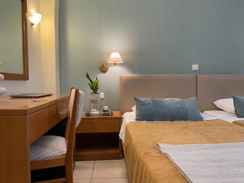 a hotel room with two beds and a desk at El Greco Hotel in Heraklio Town