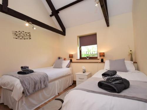 Clawtonにある2 Bed in Bude MILLPの白い壁の客室で、ベッド2台、窓が備わります。