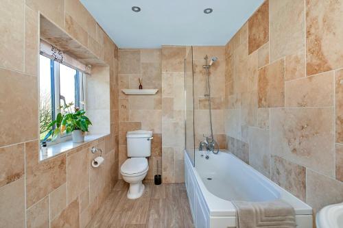 y baño con aseo, bañera y lavamanos. en Finest Retreats - Moorfield House, en Bishop Thornton