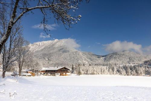 a house in the snow in front of a mountain at Wassererlehen in Bischofswiesen