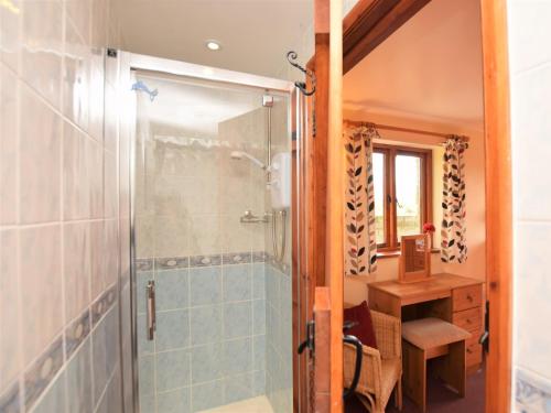 een badkamer met een douche en een glazen deur bij 2 Bed in Wadebridge QUILL in Saint Tudy