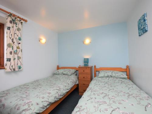 a bedroom with two beds and a dresser at 2 Bed in Wadebridge QUILL in Saint Tudy