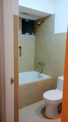 a bathroom with a toilet and a bath tub at Bello apartamento en Jesús María! in Lima