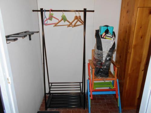 a room with a rack with shoes and a chair at Petite Maison Larice in Pila