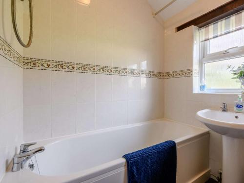 a bathroom with a bath tub and a sink at 2 Bed in Geldeston HISN8 in Geldeston
