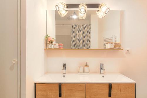 une salle de bain avec un lavabo et un miroir dans l'établissement LE LOUIS D’OR -Accès facile Gare/Eurexpo/Aéoroport, à Villeurbanne