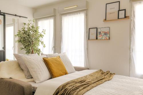 une chambre avec un lit avec des oreillers dessus dans l'établissement LE LOUIS D’OR -Accès facile Gare/Eurexpo/Aéoroport, à Villeurbanne