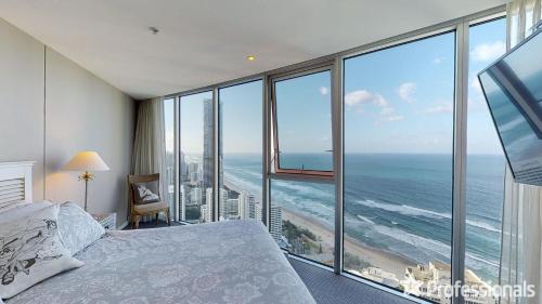 a bedroom with a bed and a view of the ocean at Number 1 H Residences - WiFi, Parking & More by Gold Coast Holidays in Gold Coast