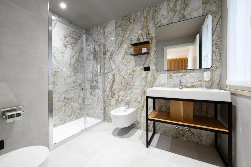 a bathroom with a sink and a mirror at Hotel Arya by Mauro in Sirmione