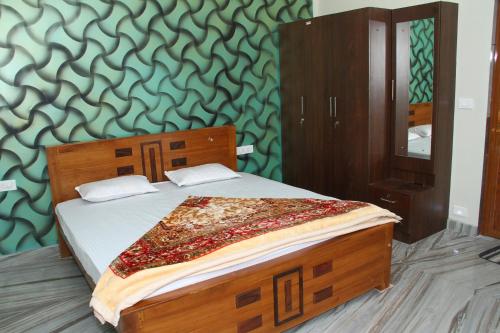 a bedroom with a bed with a wooden frame and a mirror at Airy Homestay Ooty by Lexstays in Ooty
