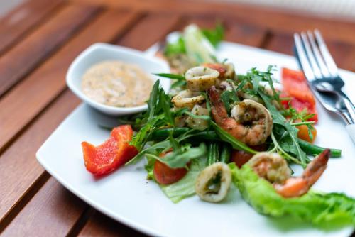a plate of food with shrimp and vegetables on a table at Skyline Boutique Hotel in Phnom Penh
