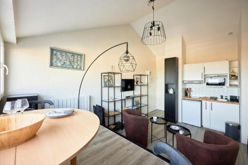 une cuisine et un salon avec une table et des chaises dans l'établissement Le Répit - Vue port à 200m de la plage, à Courseulles-sur-Mer