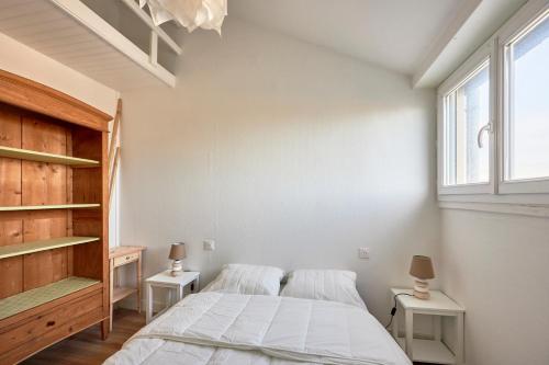 une chambre avec un lit et deux tables de nuit dans l'établissement Le Répit - Vue port à 200m de la plage, à Courseulles-sur-Mer