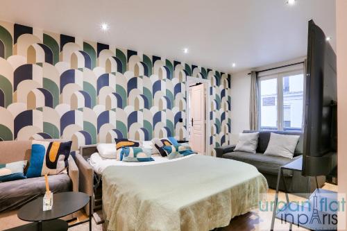 um quarto com duas camas e uma televisão e um sofá em Urban Flat 103 - Spacious Flat near Grands Boulevards em Paris