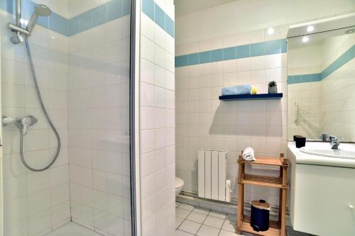 ein Bad mit einer Dusche und einem Waschbecken in der Unterkunft Les Pieds dans le Sable - Appt vue mer in Saint-Cast-le-Guildo