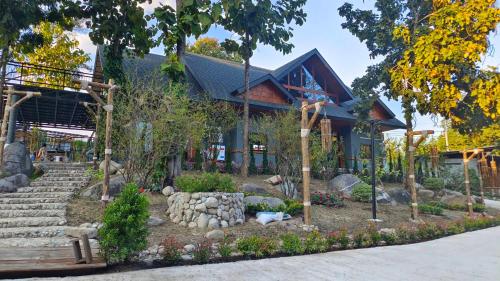 un edificio con un jardín delante de él en Lhong Chiang Dao Glamping หลงเชียงดาว, en Chiang Dao