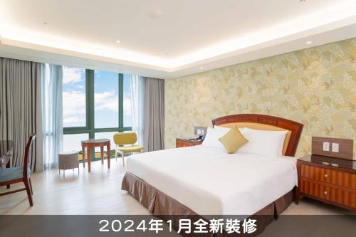a hotel room with a bed and a desk and a room at Formosan Naruwan Hotel in Taitung City