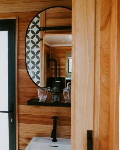 a bathroom with a mirror and a white sink at Luxury Solace Cabin - River Cabin in Rawsonville