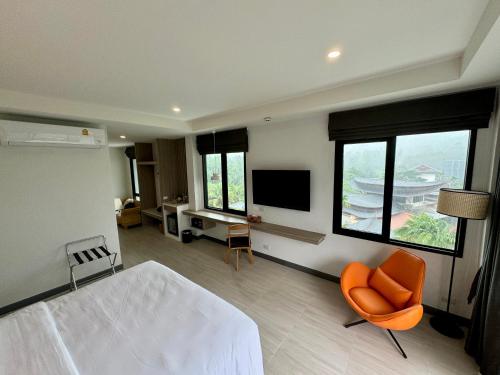 Keereen Resort - Ao Nang Krabi في شاطيء آونانغ: غرفة نوم بسرير وتلفزيون وكرسي