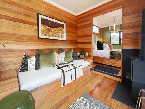 a bedroom with a bed in a room with wooden walls at Luxury Solace Cabin - River Cabin in Rawsonville