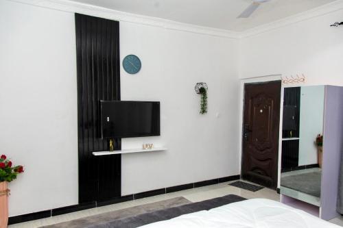 a bedroom with a tv on a white wall at BryMac Hotel in Koforidua