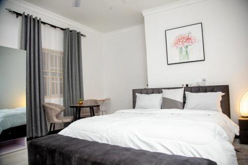 a bedroom with a large white bed and a table at BryMac Hotel in Koforidua