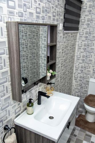 a bathroom with a sink and a mirror at BryMac Hotel in Koforidua