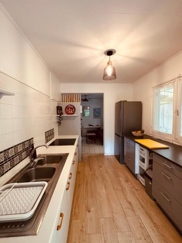 a kitchen with a sink and a refrigerator at Ti Caz Marley - Bassin Manapany-Les-Bains in Saint-Joseph