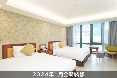 a hotel room with two beds and a desk at Formosan Naruwan Hotel in Taitung City